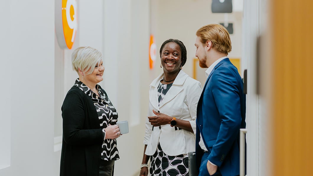 Satu Martikainen, Beatrice Kraft ja Ville-Pekka Savolainen juttelevat iloisesti Kuopion konttorin käytävällä